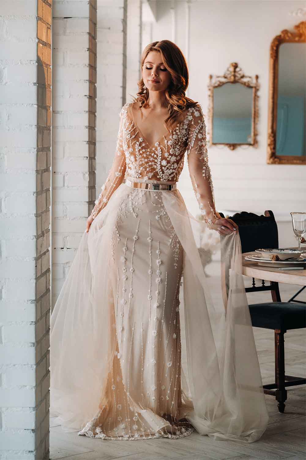 A beautiful bride in a long - sleeved wedding dress.